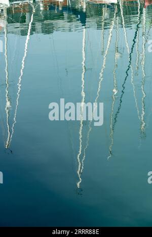 Abstract image, yacht masts reflected in aqua blue water Stock Photo