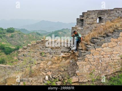 230514 -- ZUNHUA, May 14, 2023 -- This aerial photo shows Zhao Chunsheng patrolling the Great Wall in Zunhua City, north China s Hebei Province, May 13, 2023. Zhao Chunsheng, 52, is a villager from Qianhouzhangzi Village, Houjiazhai Township of Zunhua City. In 2018, he was hired by local cultural protection department as a Great Wall protector. Zhao is responsible for guarding about five kilometers of the Great Wall built in Ming dynasty 1368-1644, including five watch towers and four beacon towers. Every two or three days, he would patrol the Great Wall, clear rubbish and weeds, and arrange f Stock Photo