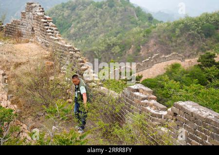 230514 -- ZUNHUA, May 14, 2023 -- Zhao Chunsheng patrols the Great Wall in Zunhua City, north China s Hebei Province, May 13, 2023. Zhao Chunsheng, 52, is a villager from Qianhouzhangzi Village, Houjiazhai Township of Zunhua City. In 2018, he was hired by local cultural protection department as a Great Wall protector. Zhao is responsible for guarding about five kilometers of the Great Wall built in Ming dynasty 1368-1644, including five watch towers and four beacon towers. Every two or three days, he would patrol the Great Wall, clear rubbish and weeds, and arrange fallen bricks. The job is no Stock Photo