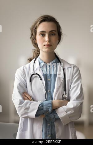 Serious medical intern, beautiful young doctor woman vertical portrait Stock Photo