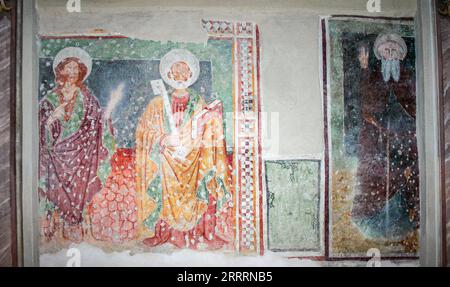 Perledo, Province of Lecco, region Lombardy, eastern shore of Lake of Como, Italy. Chiesa di Sant'Antonio Abate (Saint Anthony the Abbot). The church of Sant'Antonio Abate was built in the last quarter 13th century and underwent a remarkable renovation in 1570. Fresco dated 1458 with the figures of Saints John the Baptist and Peter and, on the right, Saint Anthony the Abbot. Stock Photo