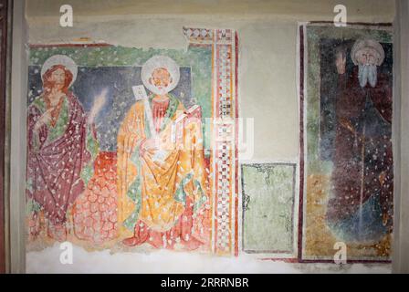 Perledo, Province of Lecco, region Lombardy, eastern shore of Lake of Como, Italy. Chiesa di Sant'Antonio Abate (Saint Anthony the Abbot). The church of Sant'Antonio Abate was built in the last quarter 13th century and underwent a remarkable renovation in 1570. Fresco dated 1458 with the figures of Saints John the Baptist and Peter and, on the right, Saint Anthony the Abbot. Stock Photo