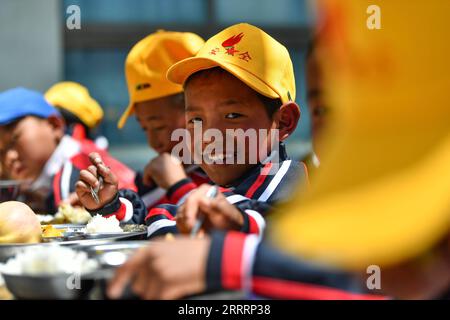 230608 -- TINGRI, June 8, 2023 -- Pupils have lunch at the canteen of a primary school of Zhaxizom Township in Tingri County, Xigaze City, southwest China s Tibet Autonomous Region, June 5, 2023. The primary school of Zhaxizom Township is the closest school to Mount Qomolangma, with a distance of just over 40 kilometers. To meet the various needs of the students, the school has established interest classes such as piano, information technology, art, broadcasting, sports, dance, and handicrafts. Currently, the primary school has only one piano. Therefore, electronic keyboards are used as substi Stock Photo