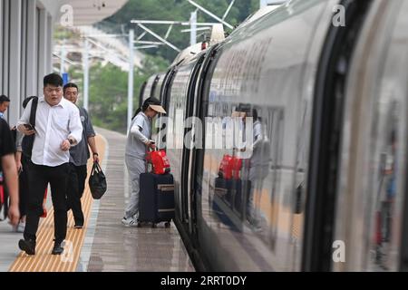 230620 -- SHENGZHOU, June 20, 2023 -- Passengers board a train at Xinchang Railway Station on the Hangzhou-Shaoxing-Taizhou intercity railway in east China s Zhejiang Province, June 19, 2023. The Hangzhou-Shaoxing-Taizhou intercity railway is among China s first group of high-speed railway projects funded by a public-private partnership PPP, with the private sector having a holding status. Since the railway s official operation in January 2022, more than 10 million passengers have travelled along it. The 266.9-kilometer rail line, with a designed speed of 350 kilometers per hour, links the cit Stock Photo