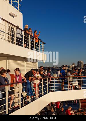 Sydney Australia /  Cruise ship passengers view the Sydney city skyline at sunset.Viewed from the stern of a departing cruise ship in Sydney Australia Stock Photo