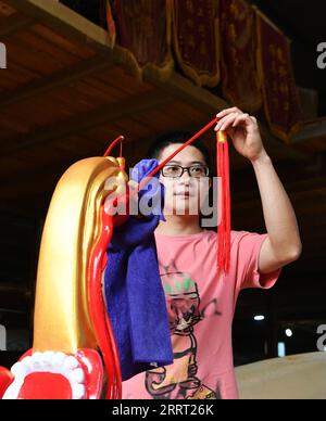 230624 -- FUZHOU, June 24, 2023 -- Fang Jianwei, nephew of inheritor of the city-level intangible cultural heritage of dragon boat making techniques Fang Shaohuang, cleans a newly built dragon boat, which will be presented to the rowers from Matsu as a gift, in Minhou of southeast China s Fujian Province, on May 31, 2023. The Dragon Boat Festival, also known as Duanwu Festival, traditionally falls on the fifth day of the fifth month in the Chinese lunar calendar. The dragon boat competition, a traditional part of the festival, has gained popularity on both sides of the Taiwan Strait, bringing Stock Photo