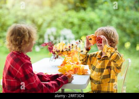 Autumn home decoration. Fall arts and crafts. Family decorating house with colorful maple leaves banner. Thanksgiving or Halloween celebration Stock Photo