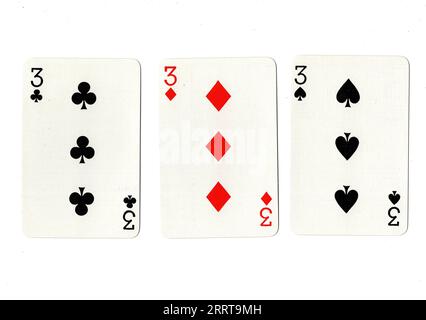 Vintage playing cards showing three threes on a white background. Stock Photo