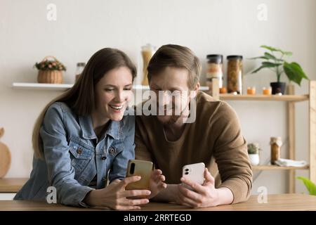 Happy young couple using Internet technologies on gadgets at home Stock Photo