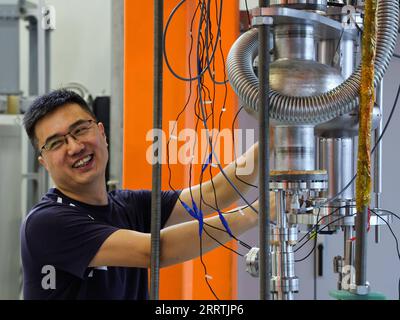 230727 -- GUANGZHOU, July 27, 2023 -- A researcher maintains equipment at the accelerator radio frequency technology laboratory of China Spallation Neutron Source CSNS in Dongguan, south China s Guangdong Province, July 18, 2023. In the city of Dongguan lies a world-class sci-tech project -- China Spallation Neutron Source CSNS. Over 1,000 research tasks have been tackled since it started in August 2018. Dubbed as a super microscope, a spallation neutron source can produce and accelerate protons before smashing them into the target to produce neutrons, and the neutron beams will be directed to Stock Photo