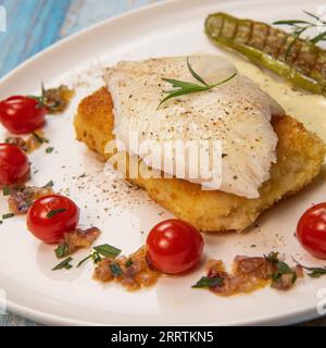 FISH RECIPE, SAINT-PIERRE SEAFISH, FILLET ACCOMPANIED BY PANNE RICE, THAI AUBERGINE, TOMATO, SHALLOT, TARRAGON AND CREAMY SAUCE WITH MUSTARD AND LEMON Stock Photo