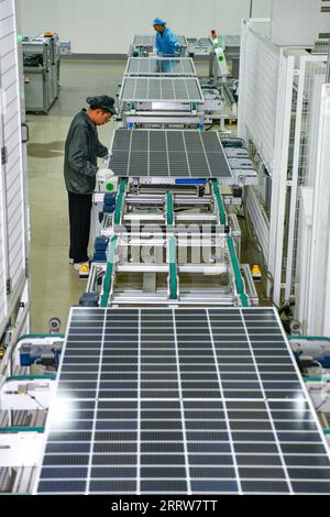 230815 -- GUIYANG, Aug. 15, 2023 -- Workers produce photovoltaic modules at the workshop of a new energy company in Yi-Hui-Miao Autonomous County of Weining, southwest China s Guizhou Province, July 19, 2023. Guizhou has seized the opportunity and made big stride in the development of new energy industry, such as wind power and photovoltaic power, in recent years. While vigorously developing green energy, Guizhou has also made full use of the land under photovoltaic panels to develop farming and livestock breeding. By the end of June 2023, the total installed capacity of new energy in Guizhou Stock Photo