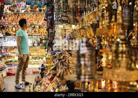 230818 -- BEIJING, Aug. 18, 2023 -- A man visits a shop at the Khan el-Khalili in Cairo, Egypt, July 28, 2023. Chongqing, a city by the Yangtze River, is called stove by Chinese people because of its high temperature in summer Cairo, located on the bank of the Nile, has long been a hot place on the edge of desert. Both cities have been vigorously promoting the night economy. Hongyadong in Chongqing is an ancient city gate that has been transformed into a giant suspended building featuring restaurants and other entertainment venues. Khan el-Khalili in Cairo, the centuries-old marketplace, is co Stock Photo