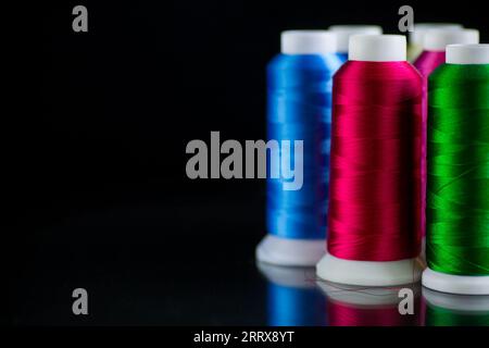 set of different color sewing threads, isolated on black background. Stock Photo
