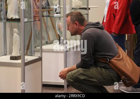 230830 -- FRANKFURT, Aug. 30, 2023 -- A visitor views an exhibit during an itinerant exhibition of Chinese Dehua white porcelain in Frankfurt, Germany, Aug. 29, 2023. An exhibition of the famous Chinese Dehua white porcelain is in full swing at the Stadthaus in Frankfurt, Germany. Over 90 items of Dehua white porcelain, known to European customers as Blanc de Chine , are on display at the exhibition. TO GO WITH Frankfurt hosts Dehua white porcelain exhibition Photo by /Xinhua GERMANY-FRANKFURT-CHINA-DEHUA WHITE PORCELAIN-EXHIBITION LixShuai PUBLICATIONxNOTxINxCHN Stock Photo