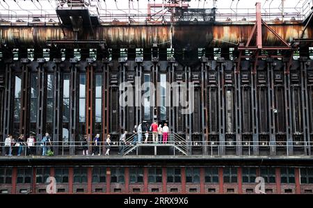 230830 -- FRANKFURT, Aug. 30, 2023 -- People visit a coke-oven plant in the Zollverein coal mine industrial complex in Essen, Germany, Aug. 16, 2023. From the Ruhr area in Germany to the Shougang industrial park in Beijing, one after another steel giants stand as witnesses to the development process of human civilization. The Ruhr area in Germany is a significant industrial zone in Europe, once a coal and steel production hub for Germany. The Zollverein coal mine industrial complex in Essen was one of the world s largest coal mines from the late 19th to the early 20th century. With Germany s t Stock Photo