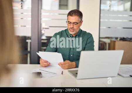 Mature business man hr manager checking cv at office meeting interview. Stock Photo