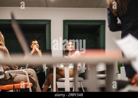Two business colleagues sat in the conference room watching and listening to the presentation Stock Photo