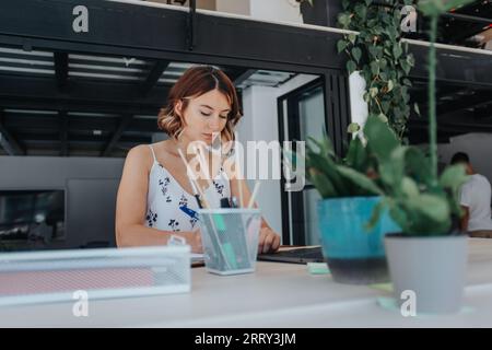 In a modern office, a confident businesswoman analysis statistics, works alone, and focuses on business development, networking, and project managemen Stock Photo