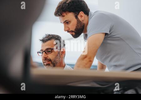Confident business professionals analyzing reports in a diverse office, utilizing technology for data analysis. Efficient team focused on problem-solv Stock Photo