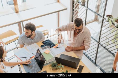 A diverse group of professionals in an office, working together on a marketing strategy. Focused on data analytic and market research for successful t Stock Photo