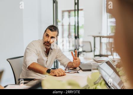 A diverse team of business professionals analyzing statistics and planning project development in an indoor office. Stock Photo