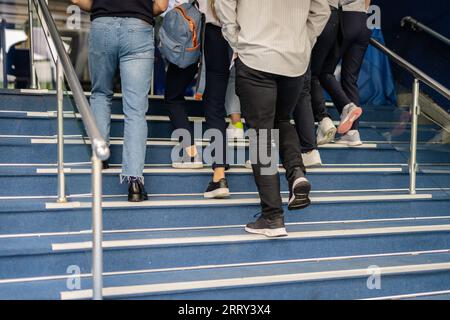 Students having a conversation while going in college for a class, back view shot , partial photo Stock Photo