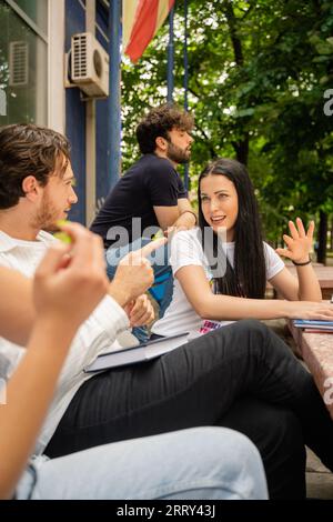 In a bustling campus yard, university students collaborate, discuss and exchange ideas, preparing for exams and sharing knowledge. Stock Photo