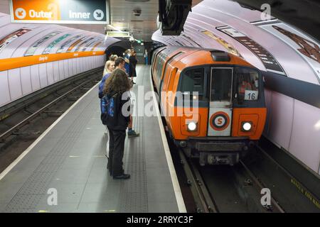 SPT subway train arriving at Glasgow Kinning Park Subway station on the Glasgow underground / subway with passengers waiting on the platform Stock Photo