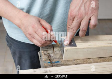 Hands of a man in the process of working with wood, a wooden board close-up. Stock Photo