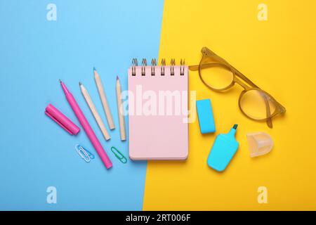 Flat lay composition with pink notebook and other school stationery on color background, space for text. Back to school Stock Photo