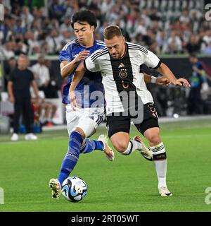 Frankfurt, Germany. 9th Sep, 2023. Joshua Kimmich (R) of Germany vies with Mitoma Kaoru of Japan during a friendly match between Germany and Japan in Wolfsburg, Germany, Sept. 9, 2023. Credit: Ulrich Hufnagel/Xinhua/Alamy Live News Stock Photo