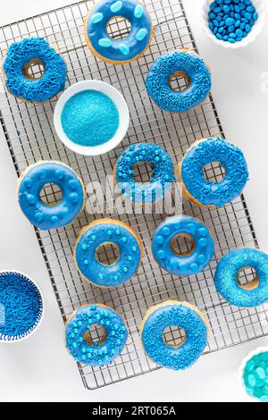 Decorated chocolate candy dipped donuts on a cooling rack. Stock Photo