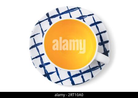Ceramic tea cup and saucer in blue-yellow-white tones isolated on a white background. View from above Stock Photo