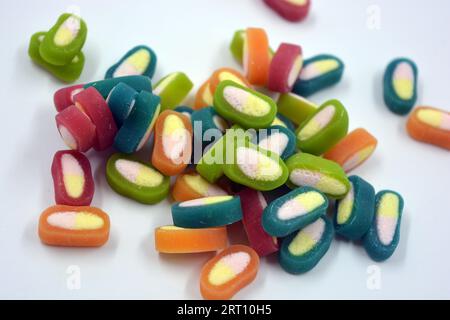 Interesting and unusual, colored caramel candies, sweets with a white center are located on a white matte background. Stock Photo