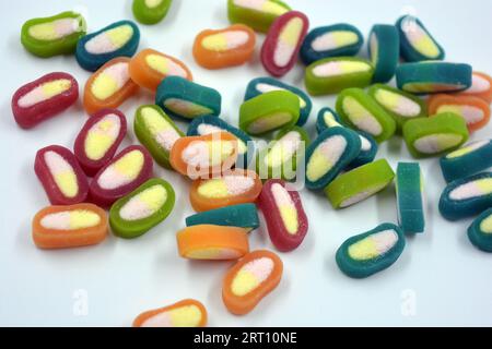 Interesting and unusual, colored caramel candies, sweets with a white center are located on a white matte background. Stock Photo