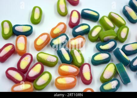 Interesting and unusual, colored caramel candies, sweets with a white center are located on a white matte background. Stock Photo
