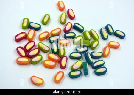 Interesting and unusual, colored caramel candies, sweets with a white center are located on a white matte background. Stock Photo