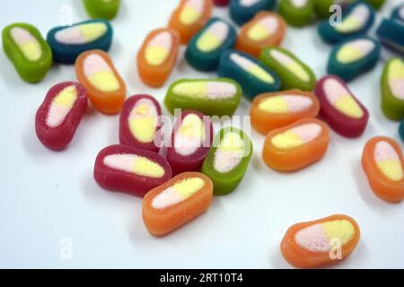 Interesting and unusual, colored caramel candies, sweets with a white center are located on a white matte background. Stock Photo