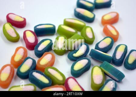 Interesting and unusual, colored caramel candies, sweets with a white center are located on a white matte background. Stock Photo