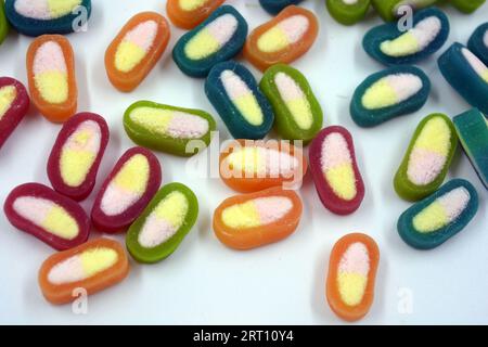 Interesting and unusual, colored caramel candies, sweets with a white center are located on a white matte background. Stock Photo
