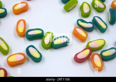 Interesting and unusual, colored caramel candies, sweets with a white center are located on a white matte background. Stock Photo