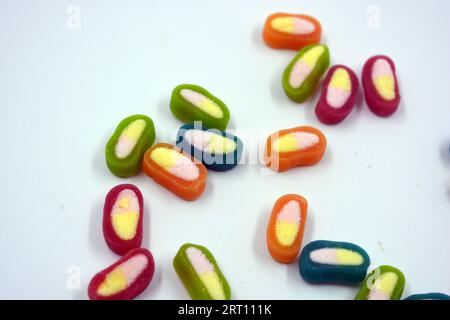 Interesting and unusual, colored caramel candies, sweets with a white center are located on a white matte background. Stock Photo