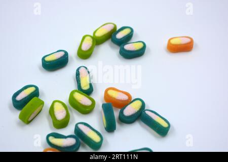 Interesting and unusual, colored caramel candies, sweets with a white center are located on a white matte background. Stock Photo