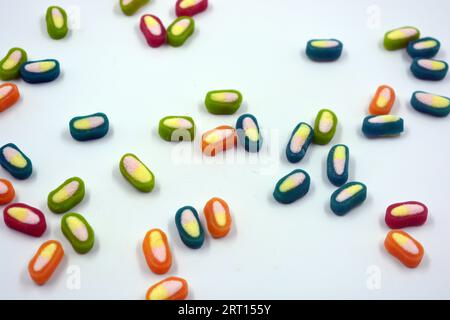 Interesting and unusual, colored caramel candies, sweets with a white center are located on a white matte background. Stock Photo