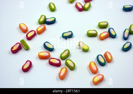 Interesting and unusual, colored caramel candies, sweets with a white center are located on a white matte background. Stock Photo