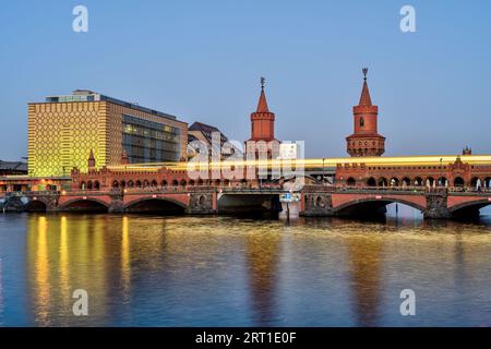 The Oberbaumbruecke in Berlin with a motion blurred yellow metro train at twilight Stock Photo