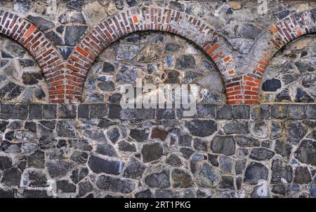 Old quarry stone wall with brick ornaments Stock Photo