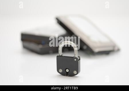 Computer hard disks and metal padlock symbolizing concept for encrypted data, cyber security on white background Stock Photo