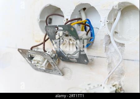 Open euro electrical socket on a grungy gray wall. Close-up. Electrical socket type F. Stock Photo